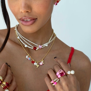 Collana dorata a strati con ciondoli a cuore e fiori colorati e anelli con pietre abbinati