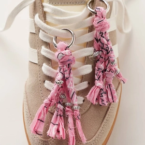 Vue détaillée de glands en coton floral fait main avec perles et fermoirs à ressort pour baskets