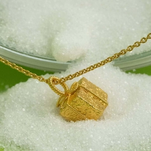 Stainless steel gold gift box necklace with textured bow pendant on white crystals