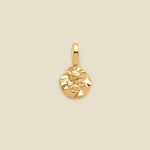 Ciondolo a fiore in oro 18K lucido con petali a strati su uno sfondo beige caldo
