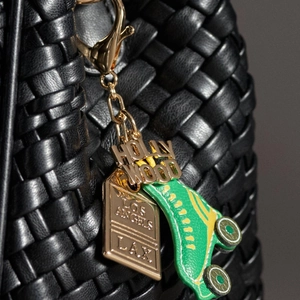 Detalle de colgantes Hollywood Los Angeles con patín retro en un bolso trenzado