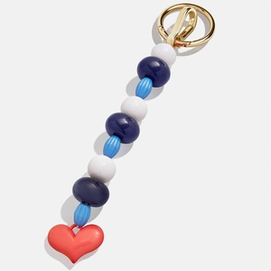 Détail du porte-clés perlé coloré avec sphères bleues et pendentif cœur rouge sur anneau