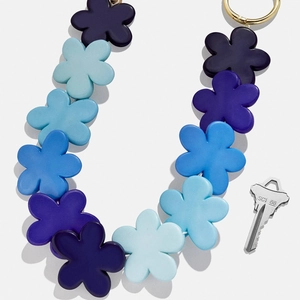 Gros plan détaillé du pendentif fleur en résine bleue et violette avec anneau doré