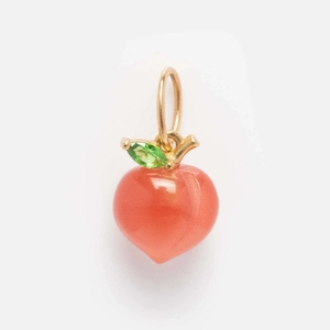 Macro detail of peach fruit pendant with orange gemstone and green crystal leaf