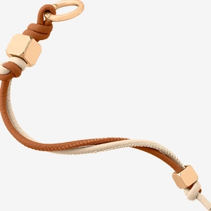 Detail eines Taschenanhängers aus Leder mit goldenem Sechskantschieber und feiner Naht