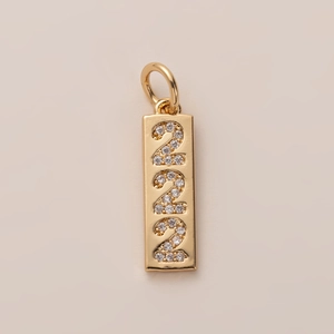 Macro shot of 18K gold plated rectangular pendant with crystal encrusted number 222