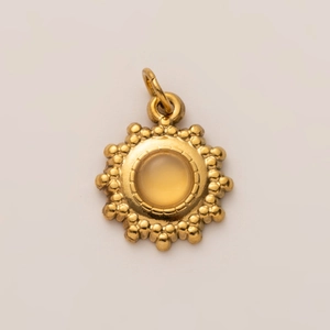 Macro detail of 18K gold plated sunflower pendant with translucent amber gemstone center