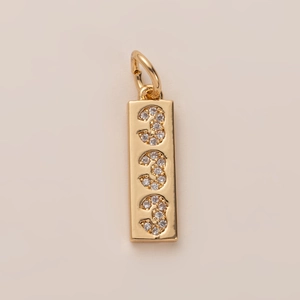 Close-up of gold rectangle pendant with three number 3 motifs set with sparkling zircons
