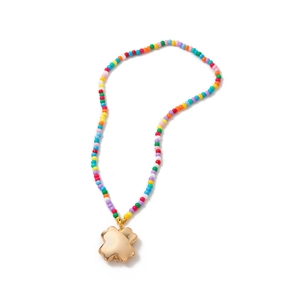 Collier de perles colorées avec un pendentif fleur dorée sur un fond blanc épuré
