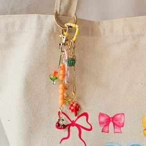Colorful DIY 18K gold plated keychain with resin beads and heart pendant on canvas bag
