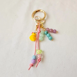 Detail of DIY keychain with gold clasp, yellow duck pendant and colorful beaded chains