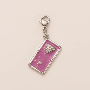 Détail d'un pendentif rectangulaire rose pailleté avec motif triangle en cristal et fermoir