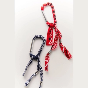 Detail of red and navy paisley bandana fabric wrapped on metal carabiner keychains