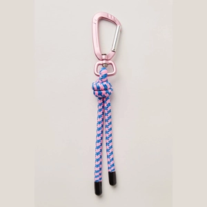 Detail of pink metal carabiner with blue and pink woven cord for bags and keys