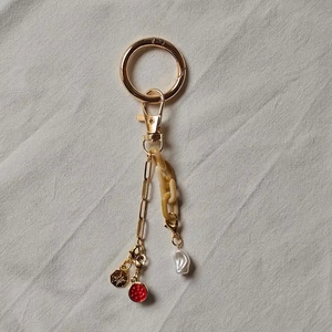 Detail of DIY 18K gold plated keychain with amber acrylic chain and pearl charm