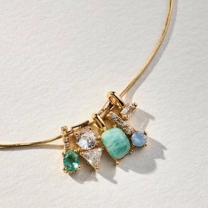 Macro shot of 14k gold-plated multi-gemstone pendant with opal and zircon crystals