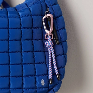 Quilted puffer bag in cobalt blue with pink carabiner and woven rope detail