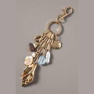 Detail of 14K gold seashell keychain with baroque pearl and blue bead charms for bags