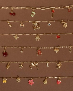 Detailed shot of 18K gold plated charms with enamel icons on elegant chain bracelets