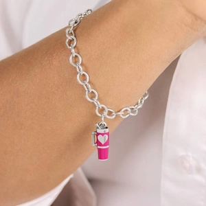 Silver chain bracelet with pink tumbler pendant and heart detail on model's wrist