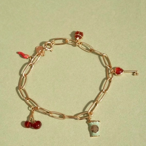 Bracelet gourmette doré 18 carats avec breloques cerise rouge et clé coeur