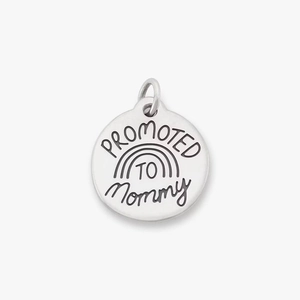 Macro detail of Promoted to Mommy engraved stainless steel round charm with rainbow