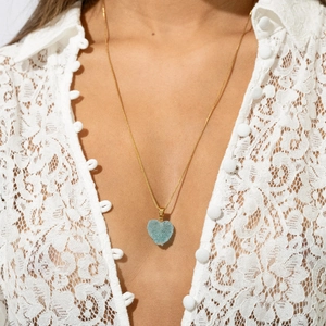 Dettaglio della collana con pendente a cuore in druzy blu e catena dorata