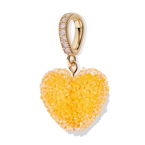 Primer plano de colgante de corazón dorado con cristales amarillos y asa diamantada