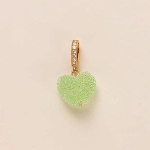Detail of light green crystal heart pendant with a gold zircon encrusted clasp