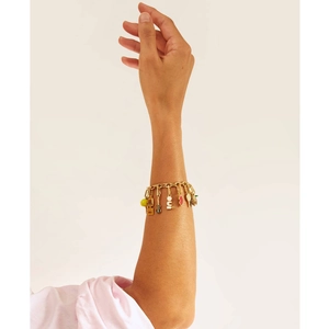 Detail of gold-plated charm bracelet featuring OUI letter and multi-pendant design