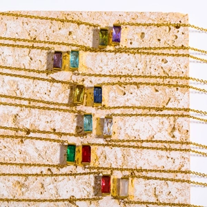 Detail of colorful baguette-cut birthstone pendants on fine gold-plated titanium chains