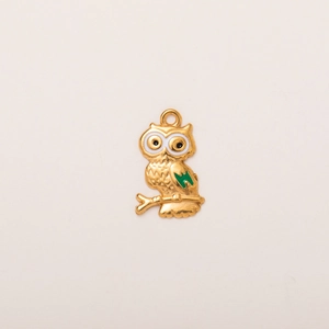 Detail of 18K gold-plated owl pendant with green enamel wings and white eyes on branch