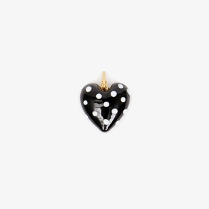 Macro view of gold plated heart pendant featuring chic black and white polka dots