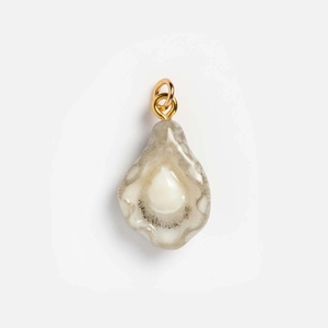 Detail view of oyster shell pendant with pearl accent and 18K gold plated metal loop