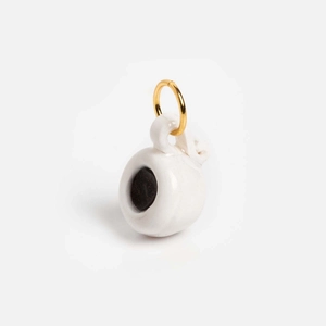 Detailed view of mini white ceramic coffee cup pendant with gold ring and black coffee inside