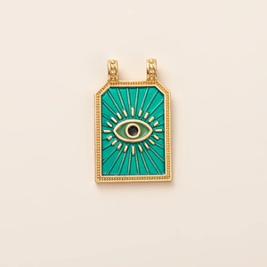 Macro detail of enamel evil eye tarot pendant with 14K gold plating and green finish