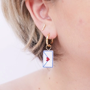 Detailed close-up of 18K gold-plated envelope earrings with heart pendant on model