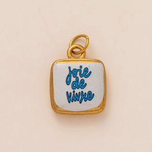 Detail of square gold pendant with blue joie de vivre text on white enamel base