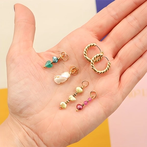 Créoles en plaqué or 18k avec breloques interchangeables en cœur et perles sur la main