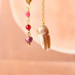 Détail de la perle baroque et boucles d'oreilles en pierres rouges avec fil plaqué or 18k