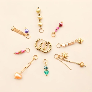 Détail de créoles plaquées or 18k avec pendentifs interchangeables soleil et cœur