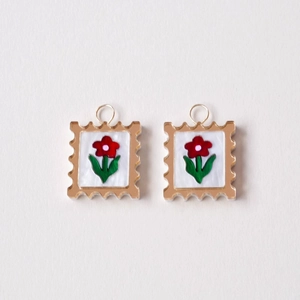 Detail view of 18K gold-plated stamp style pendants with floral patterns and pearl finish
