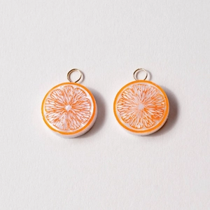 Detailed view of handmade resin orange slice charms with gold loops for DIY jewelry