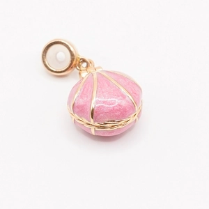 Vue détaillée d'un pendentif coquillage doré à l'or 18K avec émail rose et anneau large