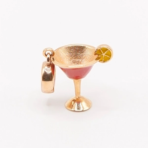 Détail d'un pendentif verre à cocktail plaqué or 18 carats avec émail rouge et jaune