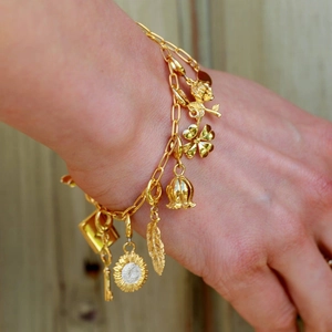 Nahaufnahme des 18K vergoldeten Büroklammer-Armbands mit Rosen- und Blumenanhängern
