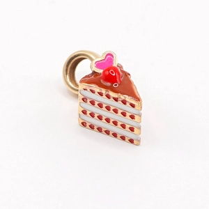 Détail d'un pendentif gâteau plaqué or 18K avec des cœurs rouges et une cerise