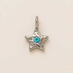 Detailed view of silver star pendant with light blue gemstone and hammered metal texture