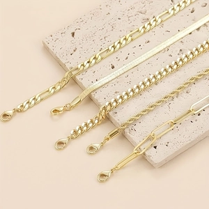 Detail von fünf vergoldeten Edelstahlketten in verschiedenen Designs mit Karabiner