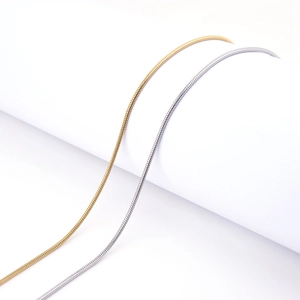 Detailed view of delicate gold and silver snake chains with smooth metallic texture